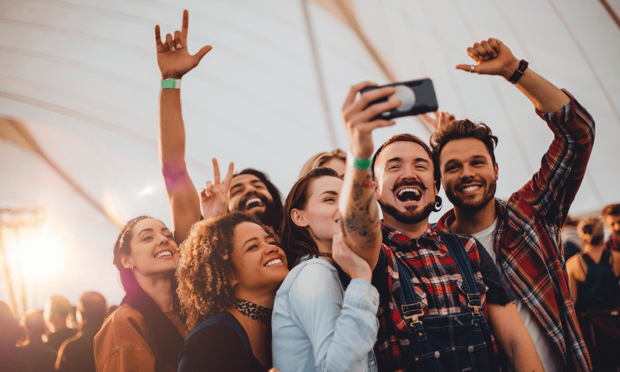 Photo illustrating social proof through User Generated Content (UGC). In the photo, a group of diverse friends (multi-cultural, young millennials) are taking a selfie while enjoying an experience together.